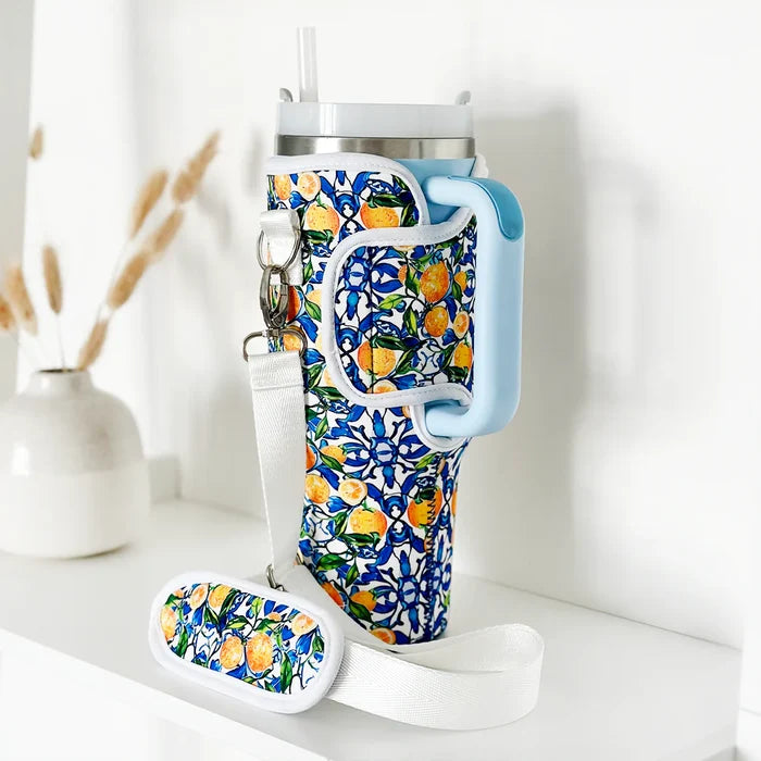 Cocopup London Amalfi Lemon Tumbler Carry Case with yellow citrus print and handle, shown next to a vase.