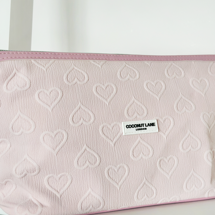Light pink expandable makeup bag with embossed heart pattern, pink trim, and Cocopup London logo label on the front.