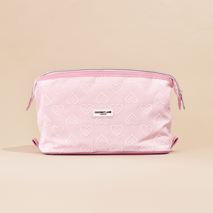Light pink expandable makeup bag with a heart pattern and zipper from Cocopup London by Coconut Lane.