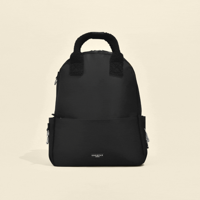 Black Cocopup London rucksack with front pocket and side zips, designed as a compact dog walking bag.