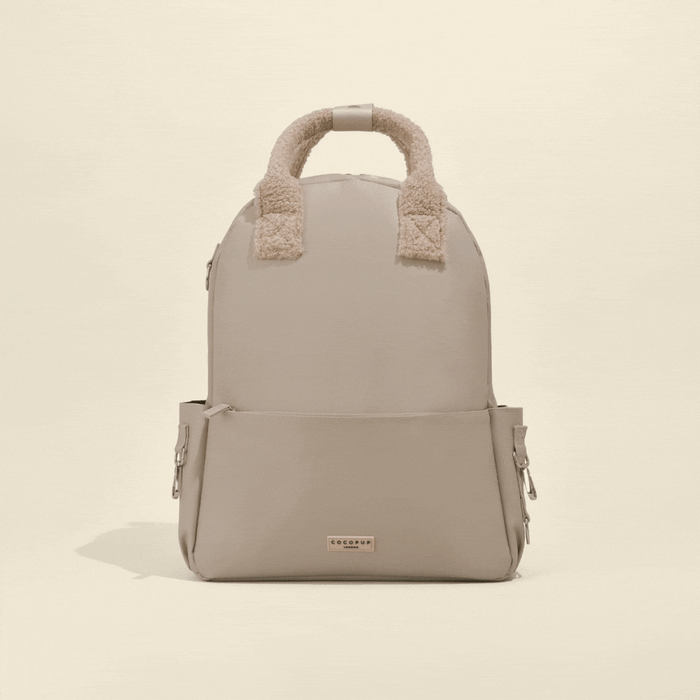 Caramel Latte Cocopup London rucksack with soft top handles and a front zip pocket.