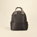 Mocha rucksack with shearling top handles, zip closure, and side pockets on a cream background.