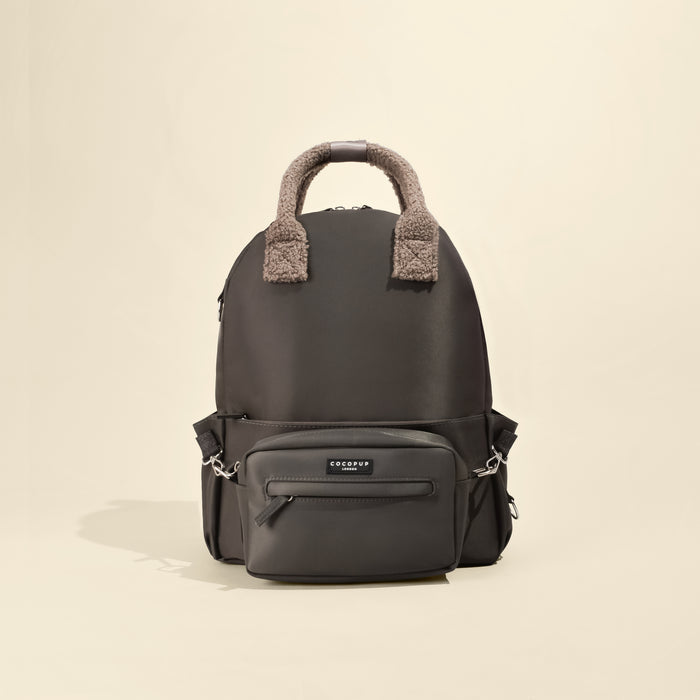 Mocha brown rucksack with a front pocket and fuzzy brown handles, set against a light beige background.
