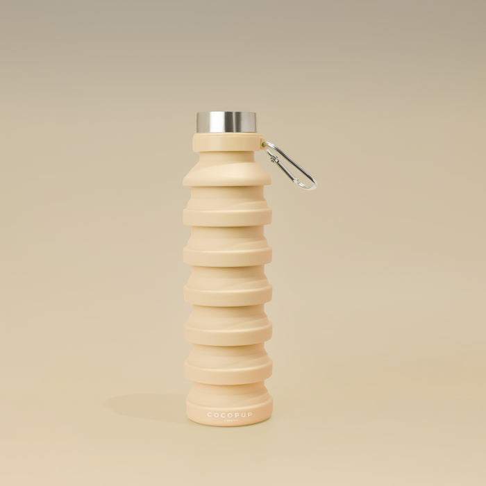 Nude collapsible water bottle with metal cap and carabiner from Cocopup London Bag Accessory Bundle.
