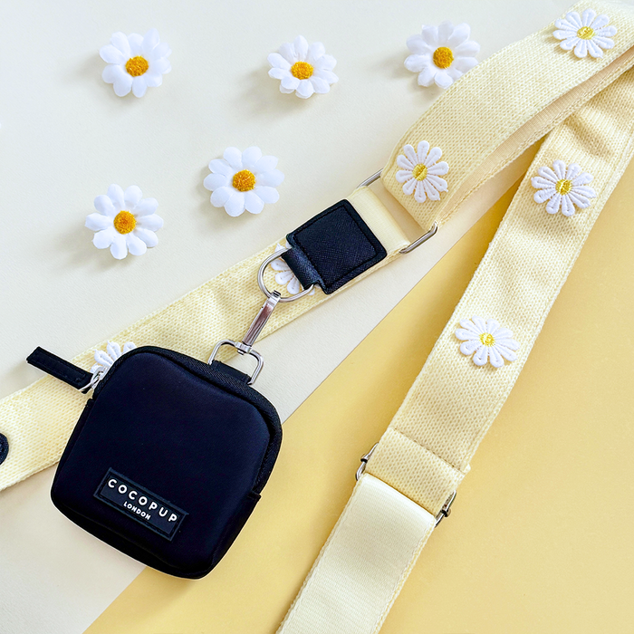 Buttercup yellow Cocopup London bag strap attached to a black pouch, shown as part of a dog walking bag set.