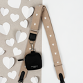 Chai Hearts Cocopup London bag strap with small black pouch, displayed on a white heart-shaped cut-out background.