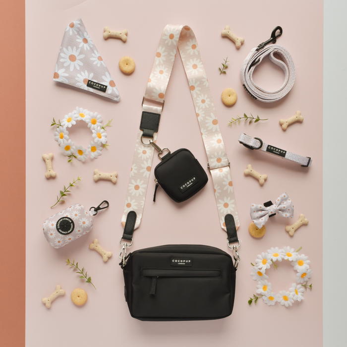 The Cocopup London Bag Strap - Daisy Chain is a versatile accessory perfect for your dog walking needs, offering daisy chains for added attachments and providing ample space to hold leashes and other essential dog items.