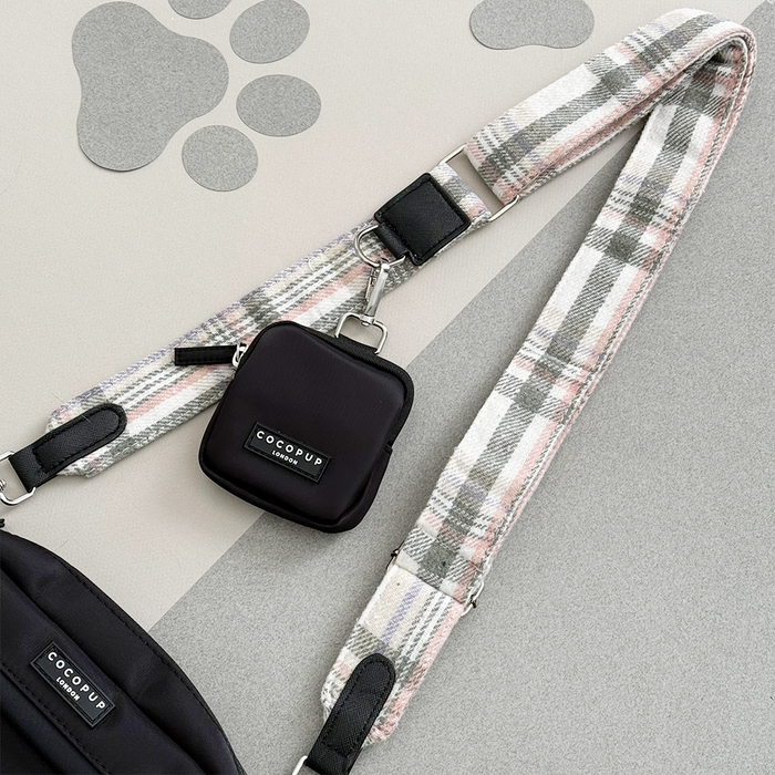 Oxford plaid bag strap and black pouch on grey background with paw prints.