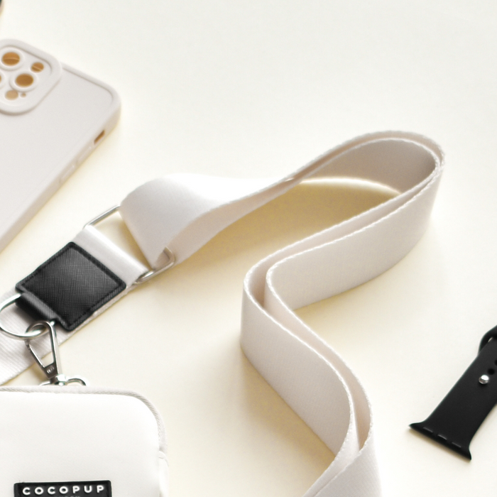 A sleek Bag Strap in Oyster White from Cocopup London paired with a phone case.