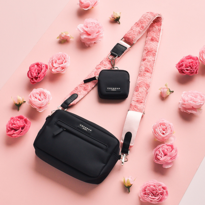Black crossbody dog walking bag with small pouch, featuring a Cocopup London pink floral strap on pastel pink.