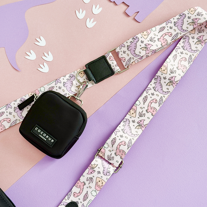 Cocopup London dog walking bag in Princess Dino design, pink and purple dino strap, black poop bag dispenser attached.
