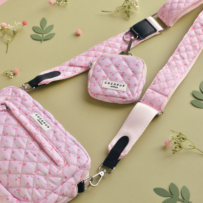 Quilted pink bag strap with ditsy floral pattern, featuring green leaves and small flowers.