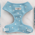 Light blue dog harness with adjustable neck, decorated with white heart pattern.