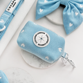 Light blue cord poop bag holder with white hearts by Cocopup London, next to a matching bow.
