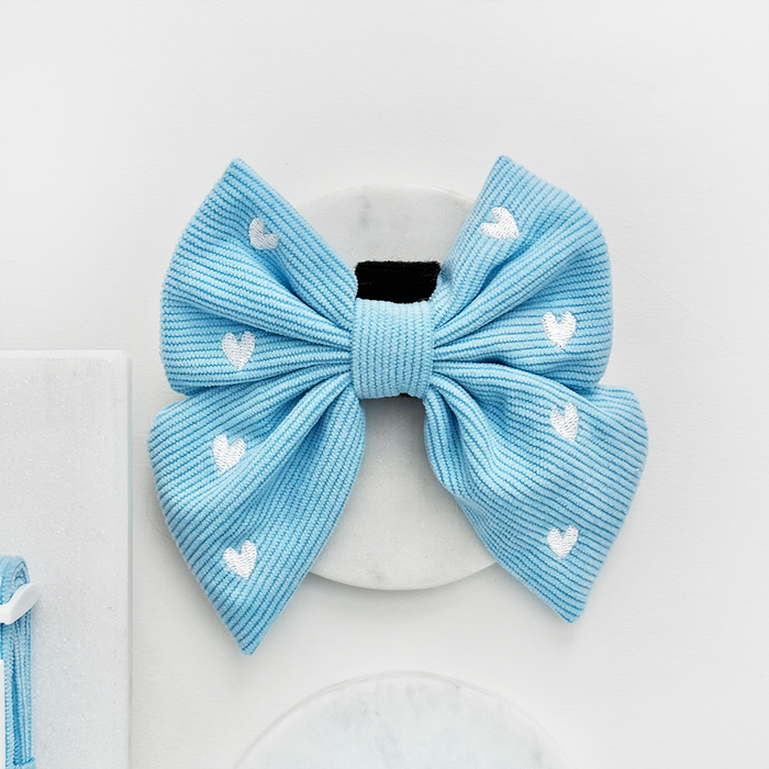Blue corduroy sailor bow tie for dogs with white heart pattern.