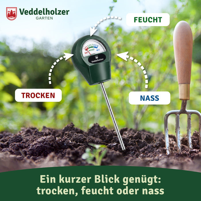 Messgerät steckt im dunklen Gartenbeet neben einer Grabegabel – „Ein kurzer Blick genügt: trocken, feucht oder nass“