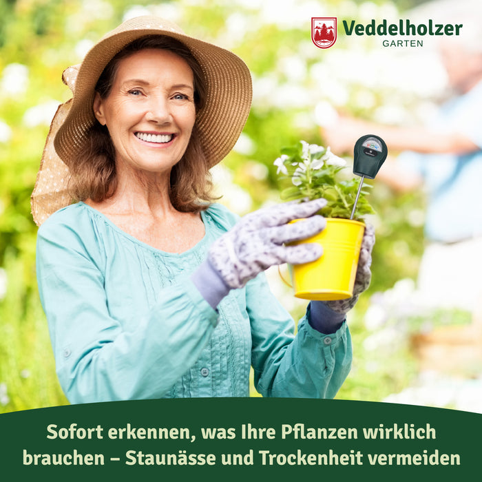 Frau mit Strohhut hält einen gelben Blumentopf, im Erdreich steckt das Messgerät – „Staunässe und Trockenheit vermeiden“