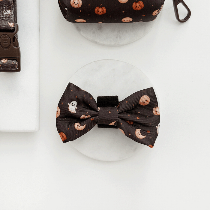 Brown dog bow tie with cute Halloween print featuring pumpkins, ghosts, and moons.