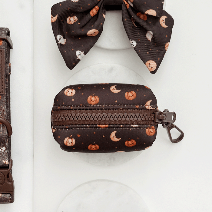 Brown poop bag holder, to hold dog poo bags, with cute Halloween print featuring pumpkins, ghosts, and moons.