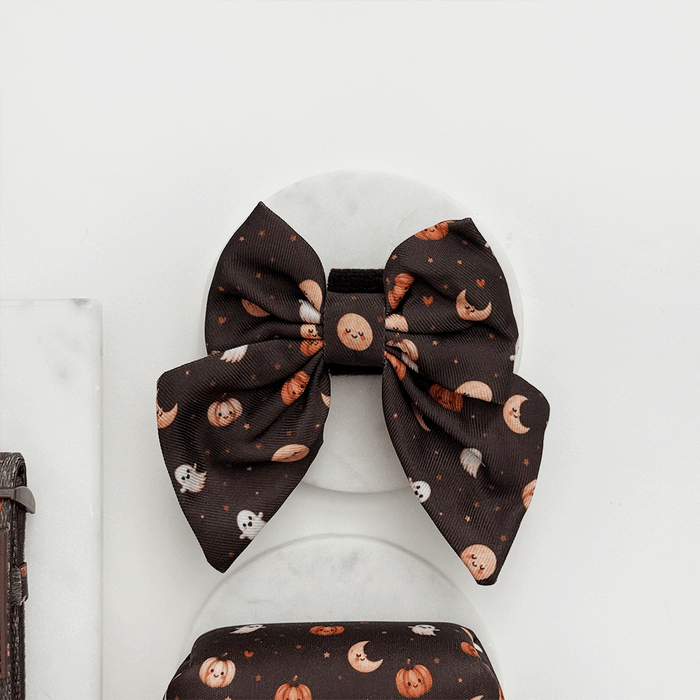 Brown dog sailor bow tie with cute Halloween print featuring pumpkins, ghosts, and moons.