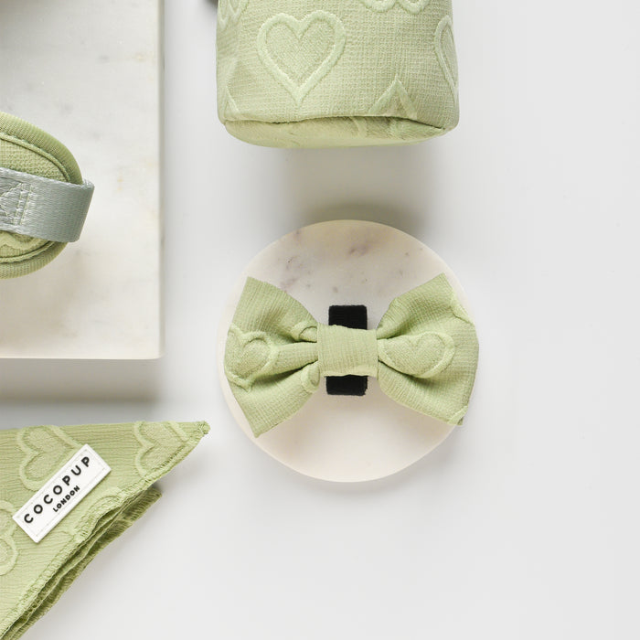 Sage green Cocopup London Luxe bow tie with white heart pattern.