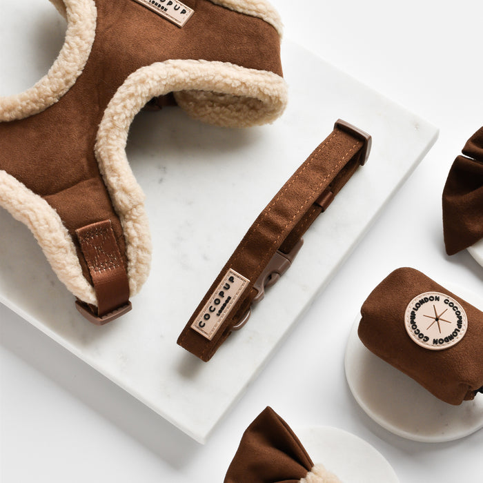 Brown aviator-style dog collar with fluffy trim, by Cocopup London, displayed on marble.