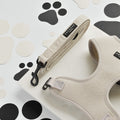 Brown herringbone tweed dog lead with beige harness featuring white paw prints.