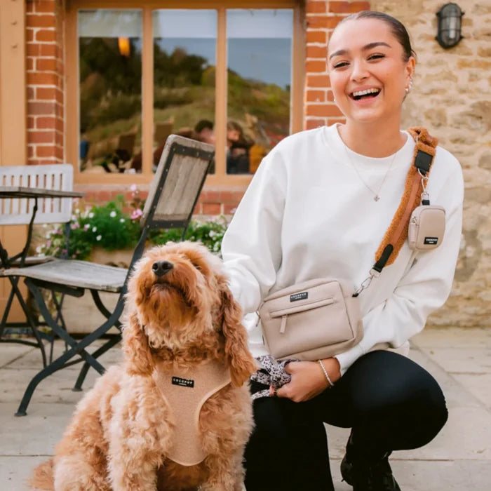 Woman and dog outside in matching beige outfits, both with Cocopup Londons caramel-colored walking bag.