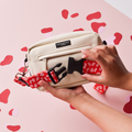 Red and pink leopard print bum bag attached to a cream dog walking bag against a pink background.
