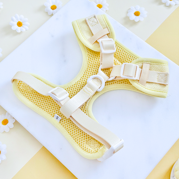 Small yellow mesh dog harness with cream straps, white buckles, and daisy pattern from Cocopup London.