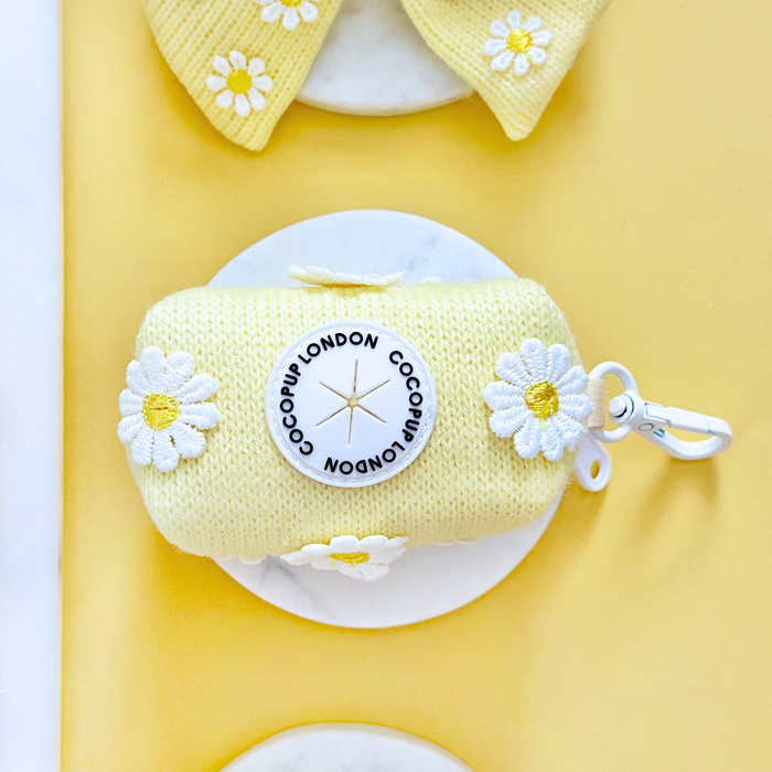Yellow knit poop bag holder with white daisy pattern by Cocopup London.