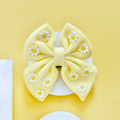 Yellow sailor bow tie with white and yellow daisy pattern from Cocopup London.
