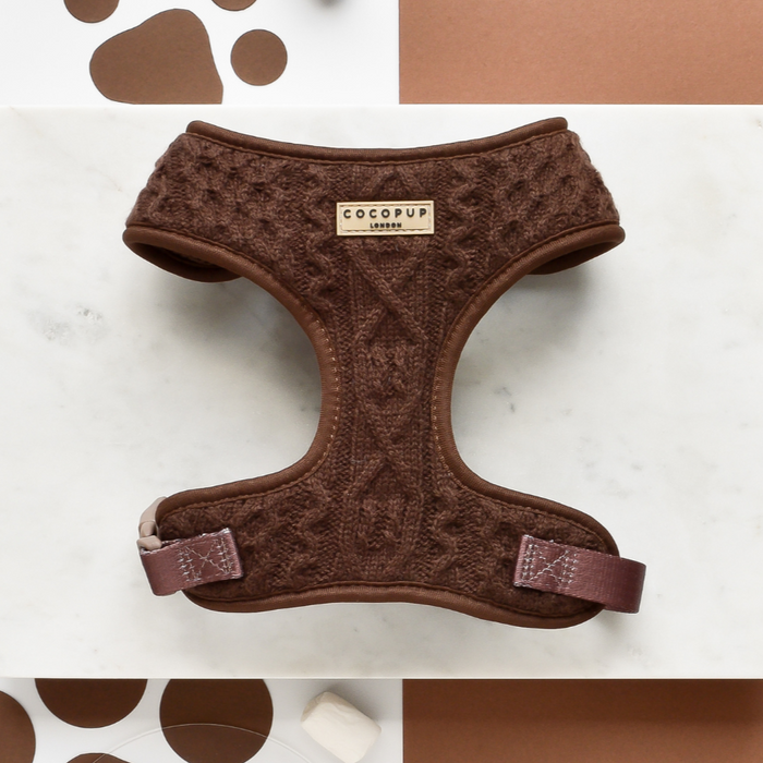 Brown cable knit harness, lead, and collar set with adjustable straps on a white and brown surface.