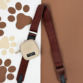 Beige Cocopup London dog walking bag with a hot cocoa cable knit strap, displayed on a paw print background.