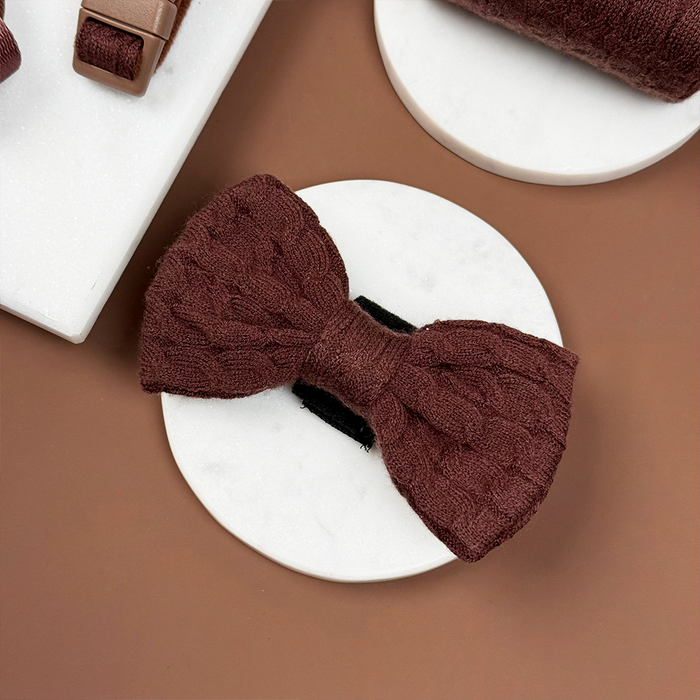 Brown cable knit bow tie with ribbed texture from Cocopup London, displayed on a white marble coaster.