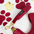 Mulled wine cable knit dog lead with gold hardware, displayed on a white surface with grey paw prints.