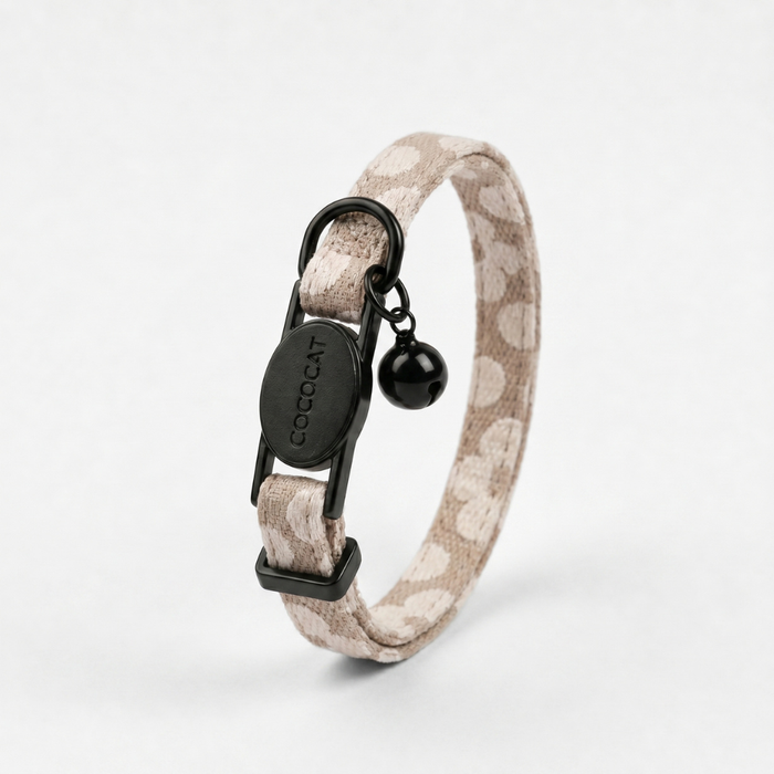 Mocha Flower-patterned cat collar with breakaway buckle, gold COCOCAT tag, and black bell.