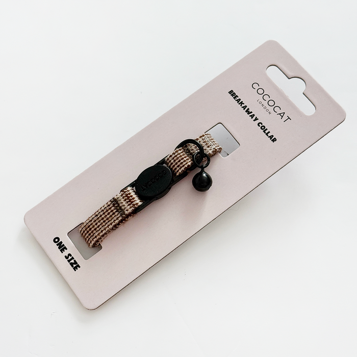 Beige and brown plaid cat collar with bell and breakaway buckle, displayed on Cocopup London branded packaging.