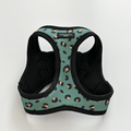 Khaki leopard print cat harness with black trim displayed on a white background.