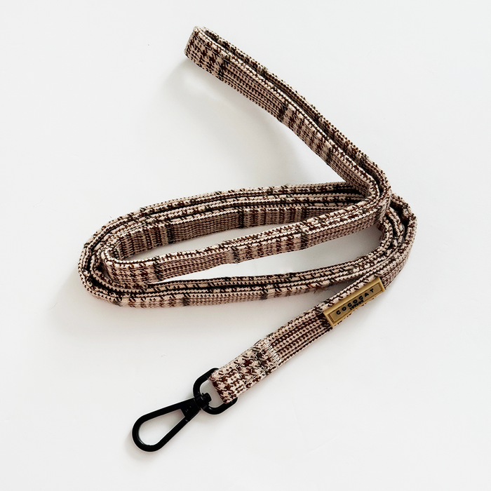 Beige and brown plaid cat lead with a black metal clip.