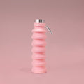 Pink Cocopup London collapsible silicone water bottle standing upright on a matching pink background.