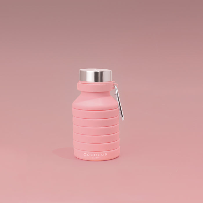 Pink Cocopup London collapsible water bottle with silver cap and carabiner, made of silicone.