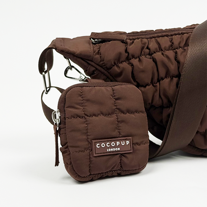 Brown crescent-shaped treat pouch and matching bag with gold zippers by Cocopup London on a white background.