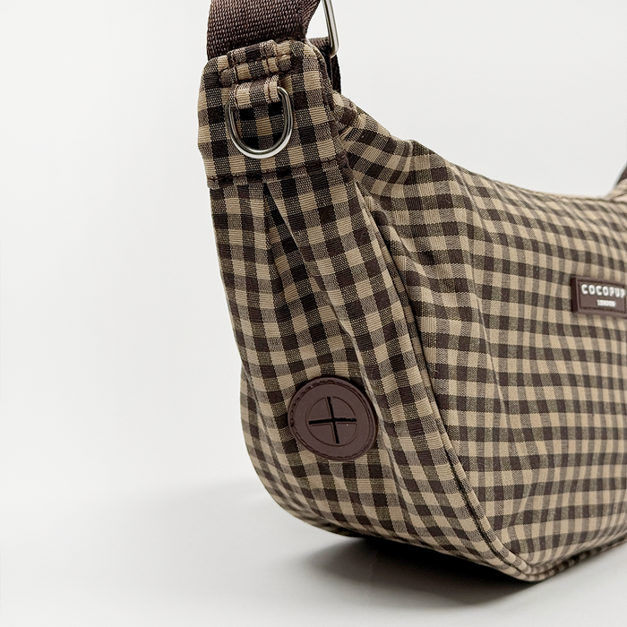 Cocopup London crescent dog walking bag in check pattern with adjustable strap and dark brown button.