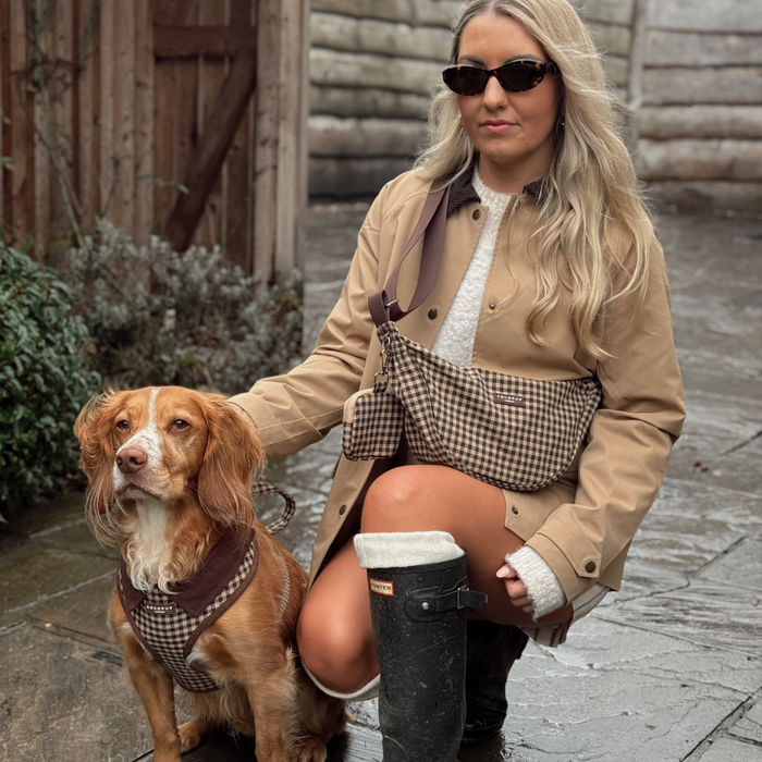 Woman in tan coat with dog wearing Cocopup London harness, lead and collar in Cotswold check pattern.