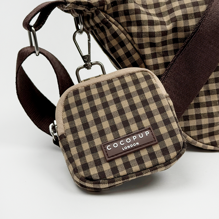 Cocopup London crescent crossbody dog walking bag in Cotswold check with matching strap, shown on a white background.