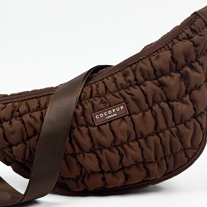 Espresso brown Cocopup London crescent crossbody dog walking bag with wide strap on a white background.