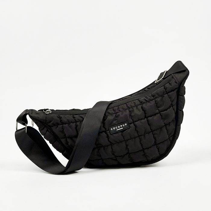 Black Cocopup London crossbody dog walking bag with a wide strap and subtle front pocket for bags.