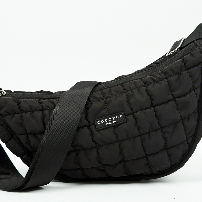 Black crescent-shaped crossbody dog walking bag bundle with silver hardware and adjustable strap.