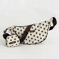 Polka dot crossbody bag with matching pouch on a light gray background